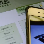 Celular e tela com logo do Simples Nacional. Foto: Marcello Casal Jr./Agência Brasil