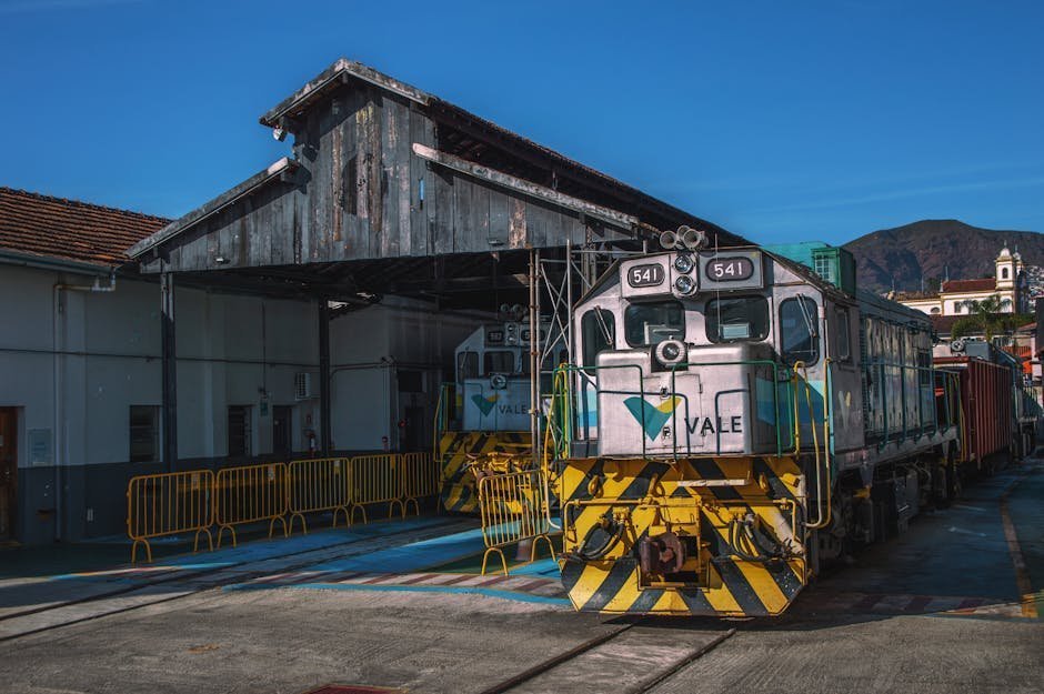 Rustic train and depot against clear sky in mountain backdrop, perfect for industrial themes.